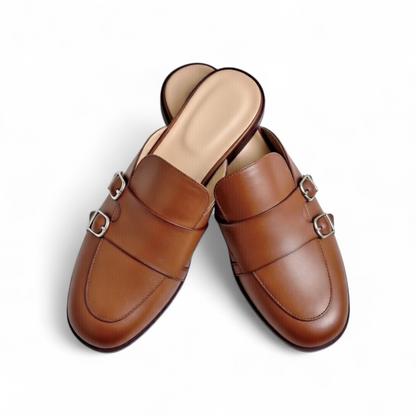 Pair of brown leather mules with buckles on a white background