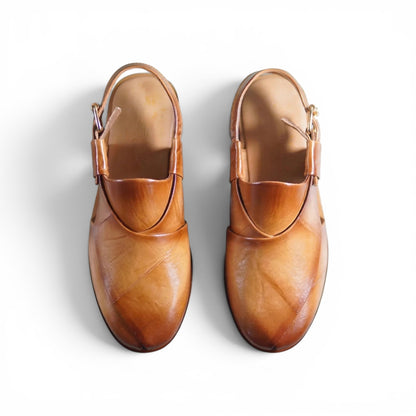 A pair of light brown leather Mary Jane-style shoes with ankle straps and buckle details, photographed from a top-down angle on a white background.