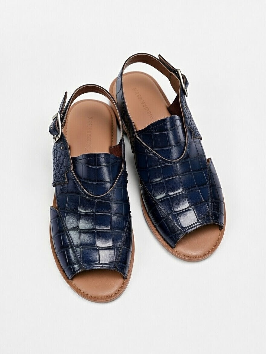 Pair of navy blue crocodile-patterned sandals on a white background