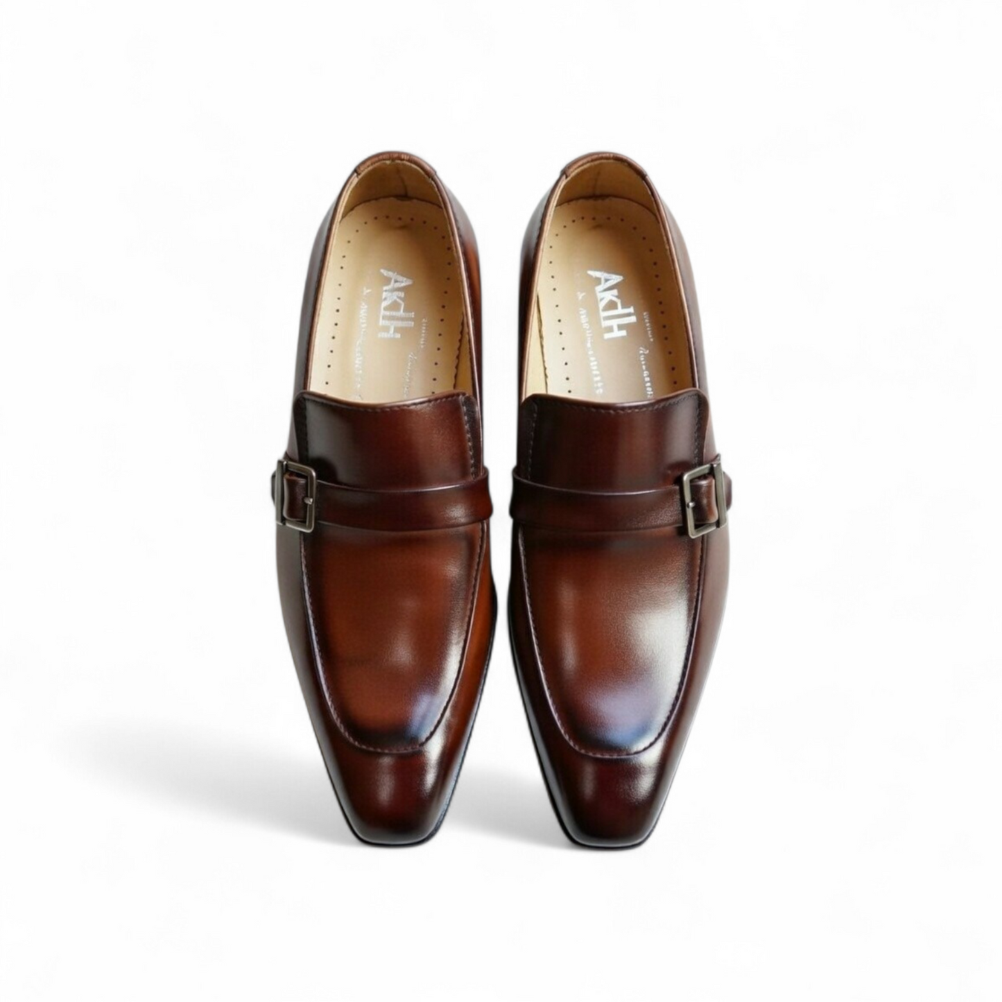 Pair of brown leather shoes with buckle details on a white background