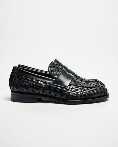 Black woven loafer shoes on a light gray background