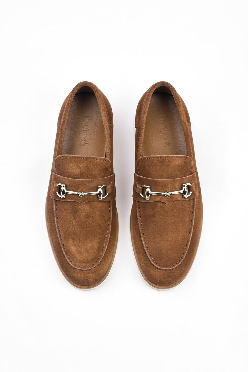Pair of brown suede loafers with metallic embellishments on a white background