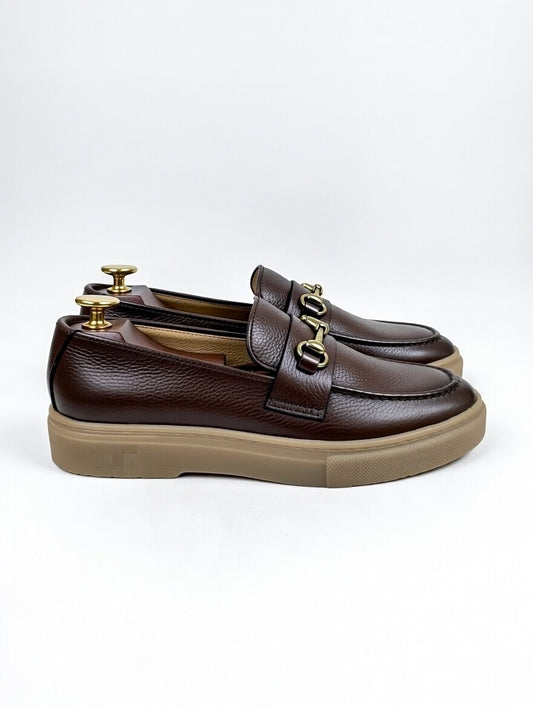 Brown loafers with gold accents on a white background