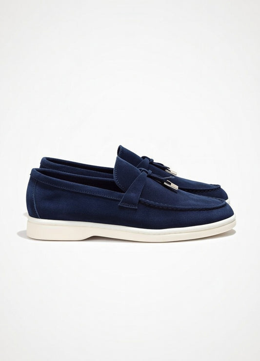 Navy loafers with tassels on a light gray background