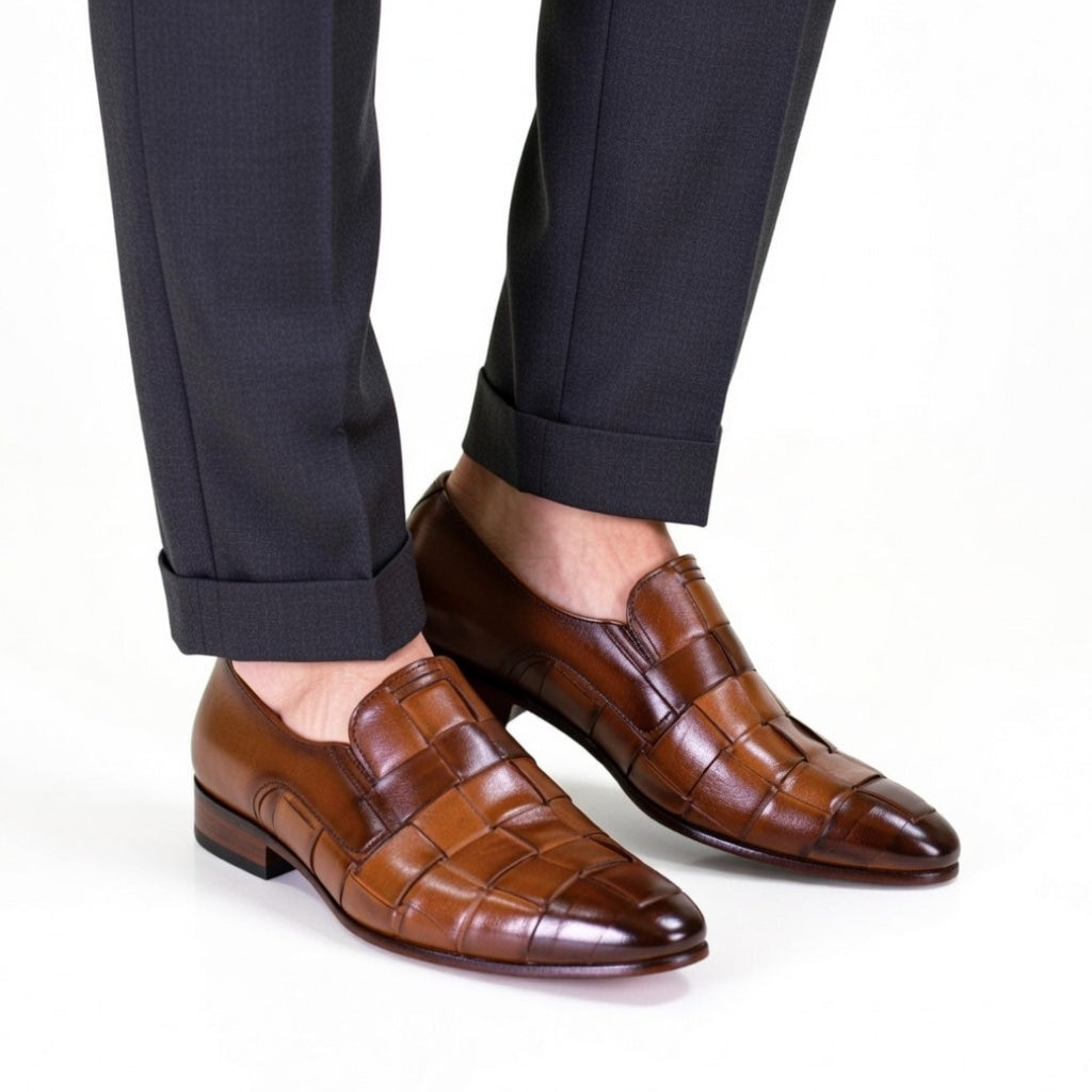 Brown dress shoes worn with dark trousers on a white background