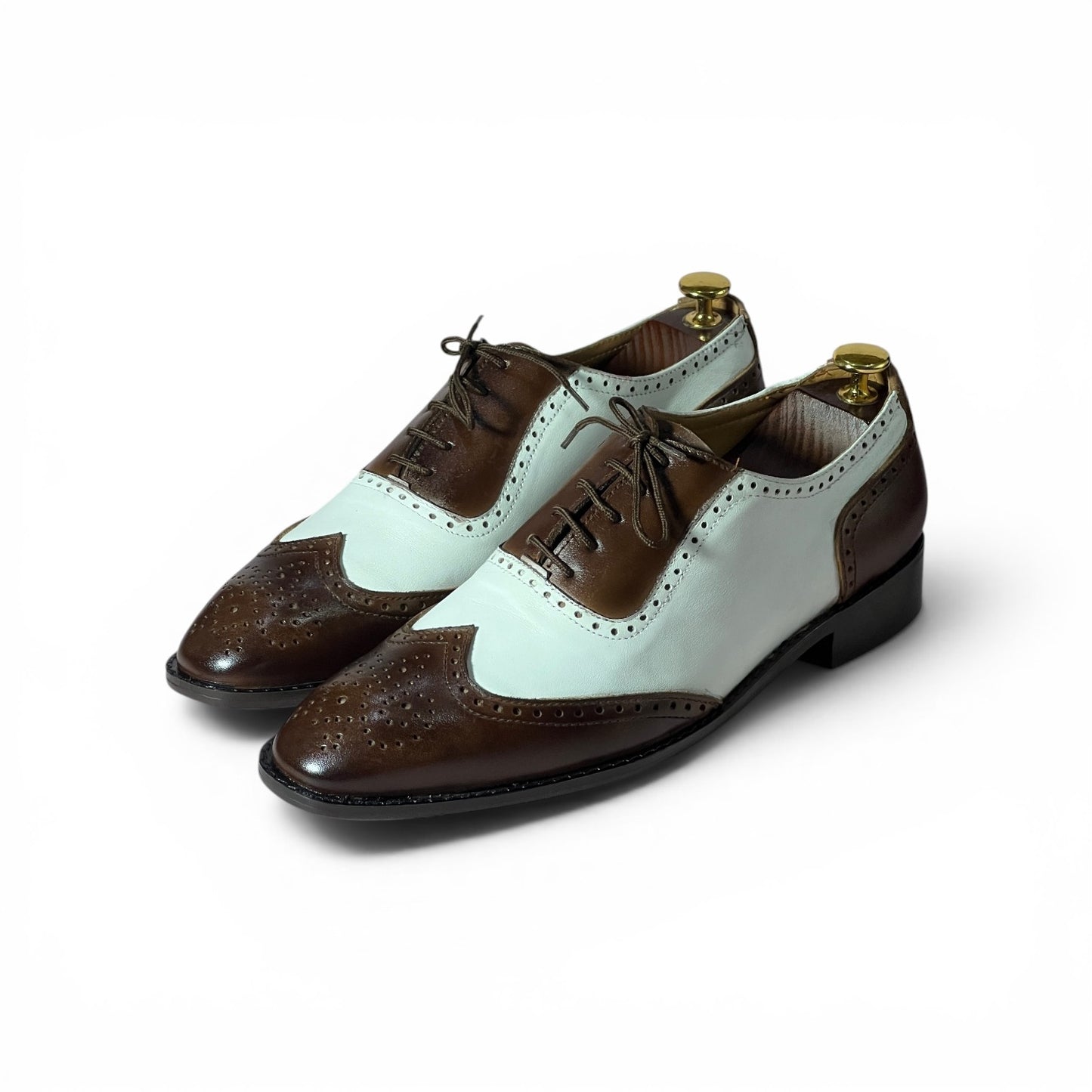 A pair of men's wingtip oxford shoes with a two-tone color-blocked design featuring dark brown brogue detailing and a pale mint green leather upper, displayed on a white background.