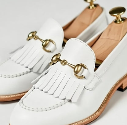 White loafers with gold accents on a white background