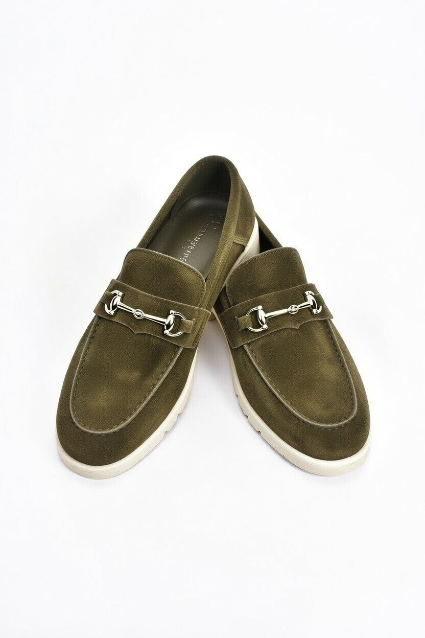 Pair of olive green loafers with metallic buckles on a white background