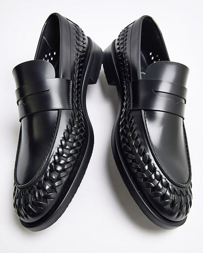 Black leather loafers with woven detailing on a white background