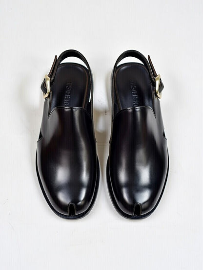 Pair of black leather shoes on a light gray background