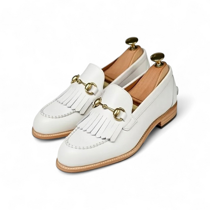 White loafers with gold details on a white background