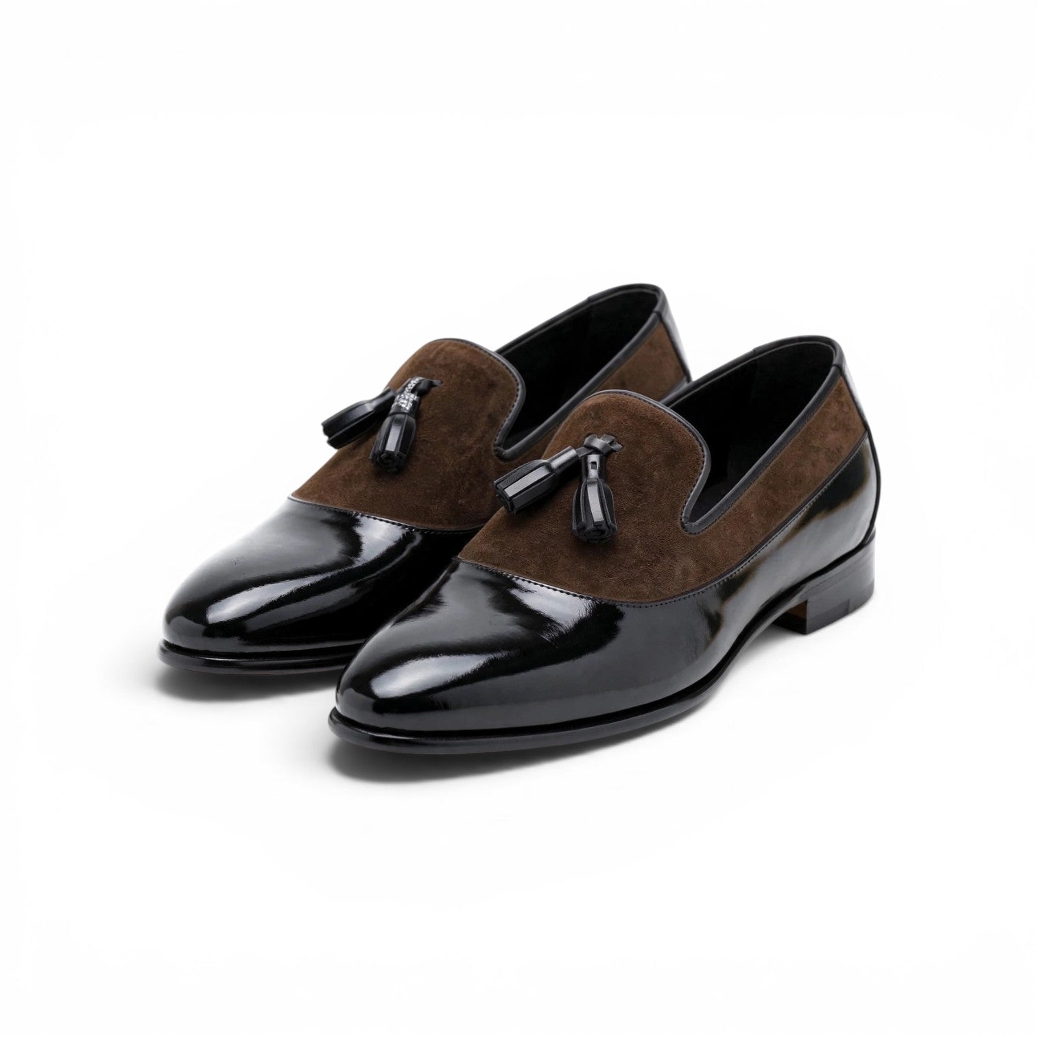 A pair of men's slip-on loafers with a glossy black patent leather toe cap and heel, and a brown suede vamp, shown on a white background.