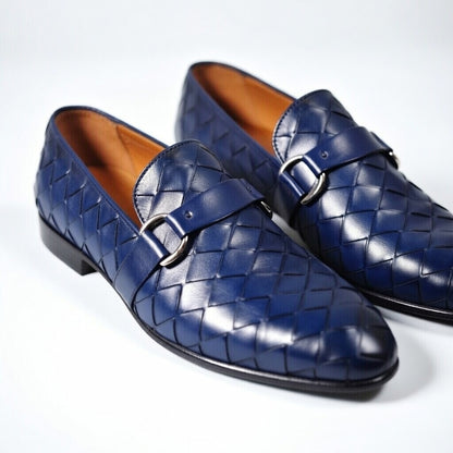 Pair of blue woven dress shoes with buckles on a white background