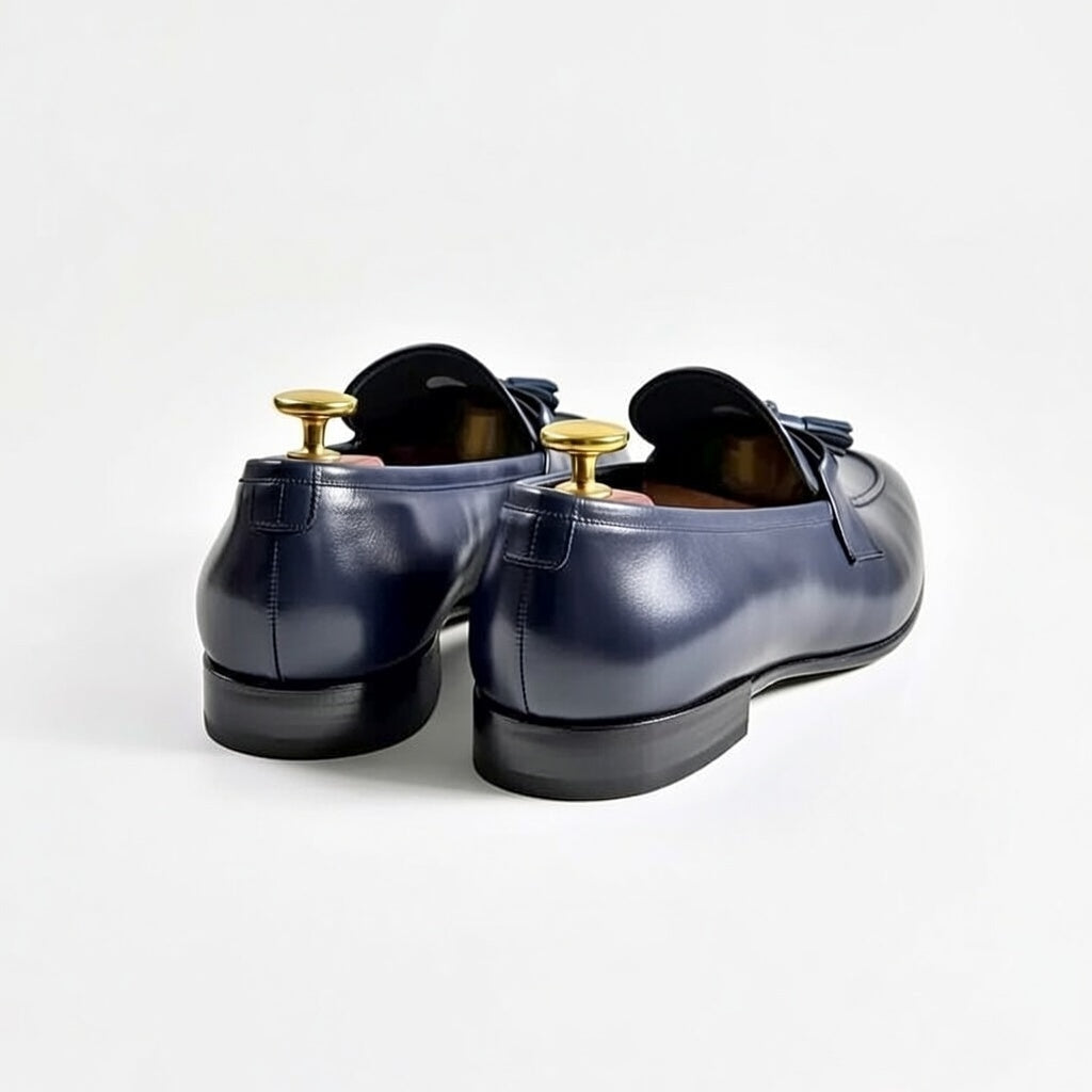 Pair of blue leather shoes with gold buckles on a white background