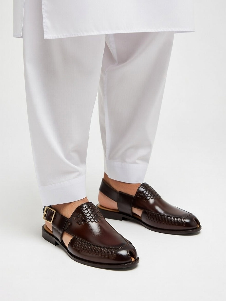 Brown leather shoes worn with white pants on a light gray background
