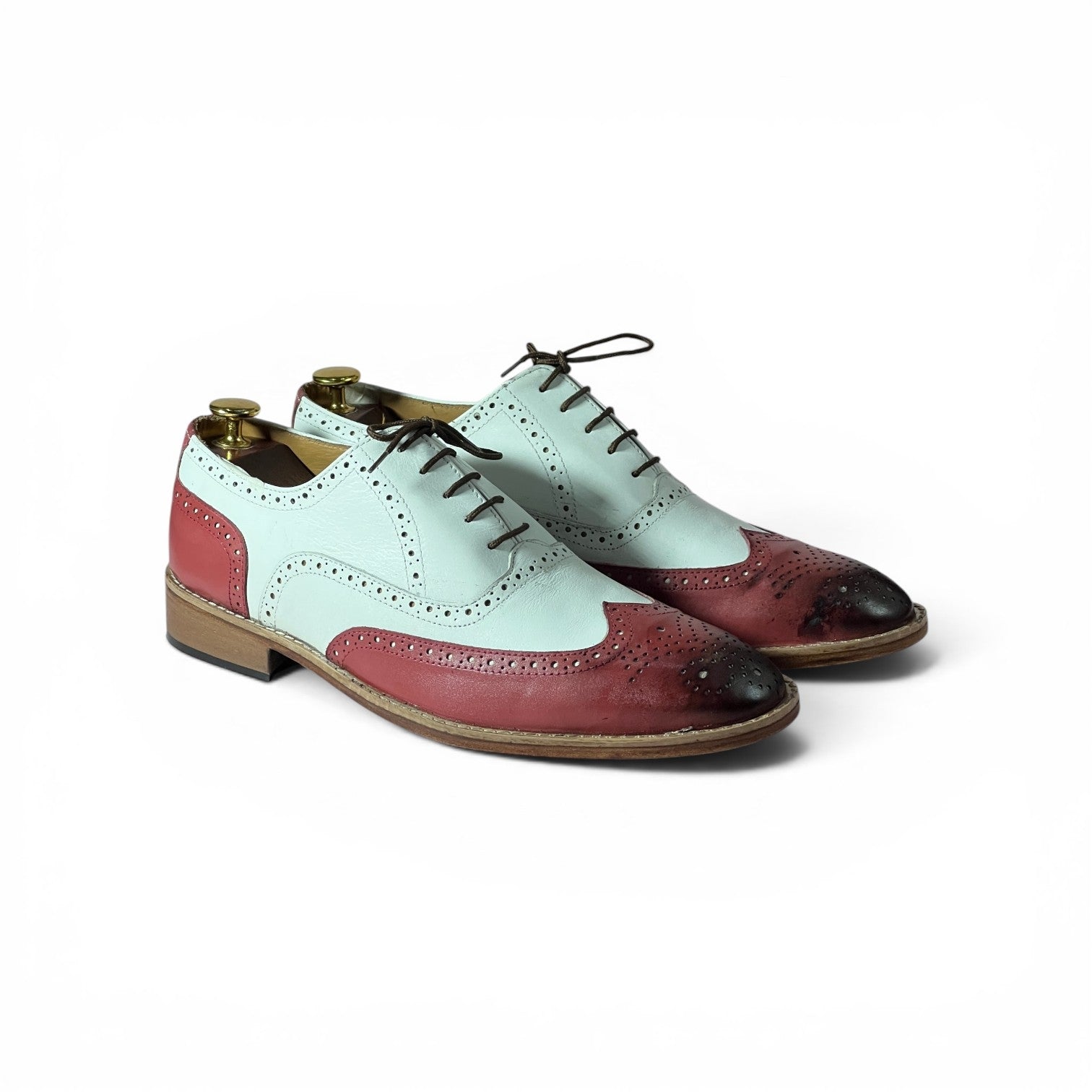 A pair of men's vintage wingtip oxford shoes with a color-blocked design featuring pale mint green, dusty rose red, and black toes, displayed on a white background.