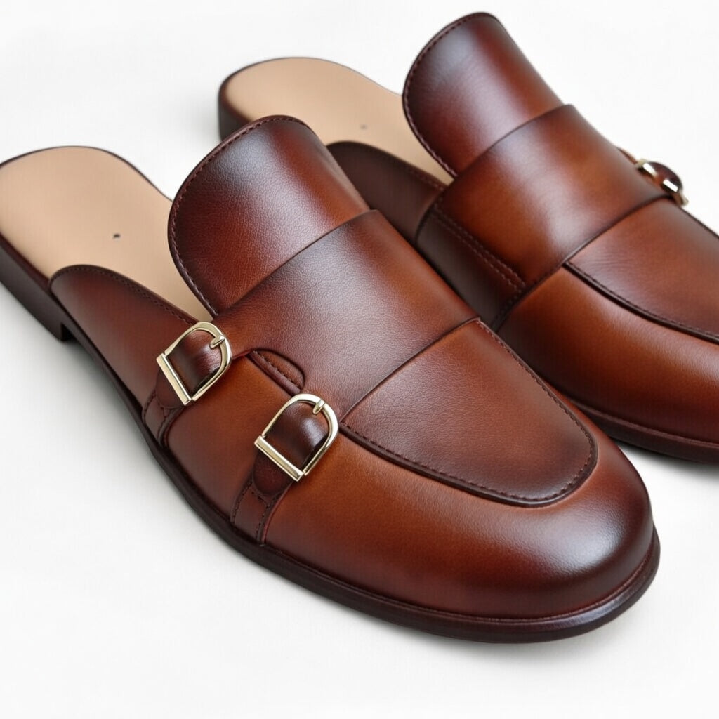 Brown leather shoes with gold buckles on a white background