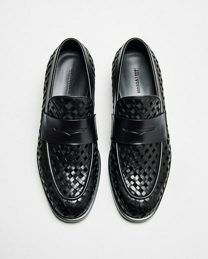 Black woven loafers on a light gray background