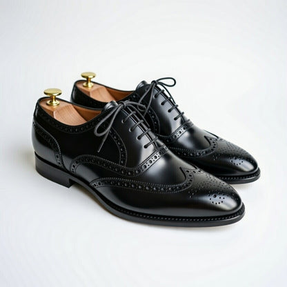 Pair of black dress shoes on a light gray background