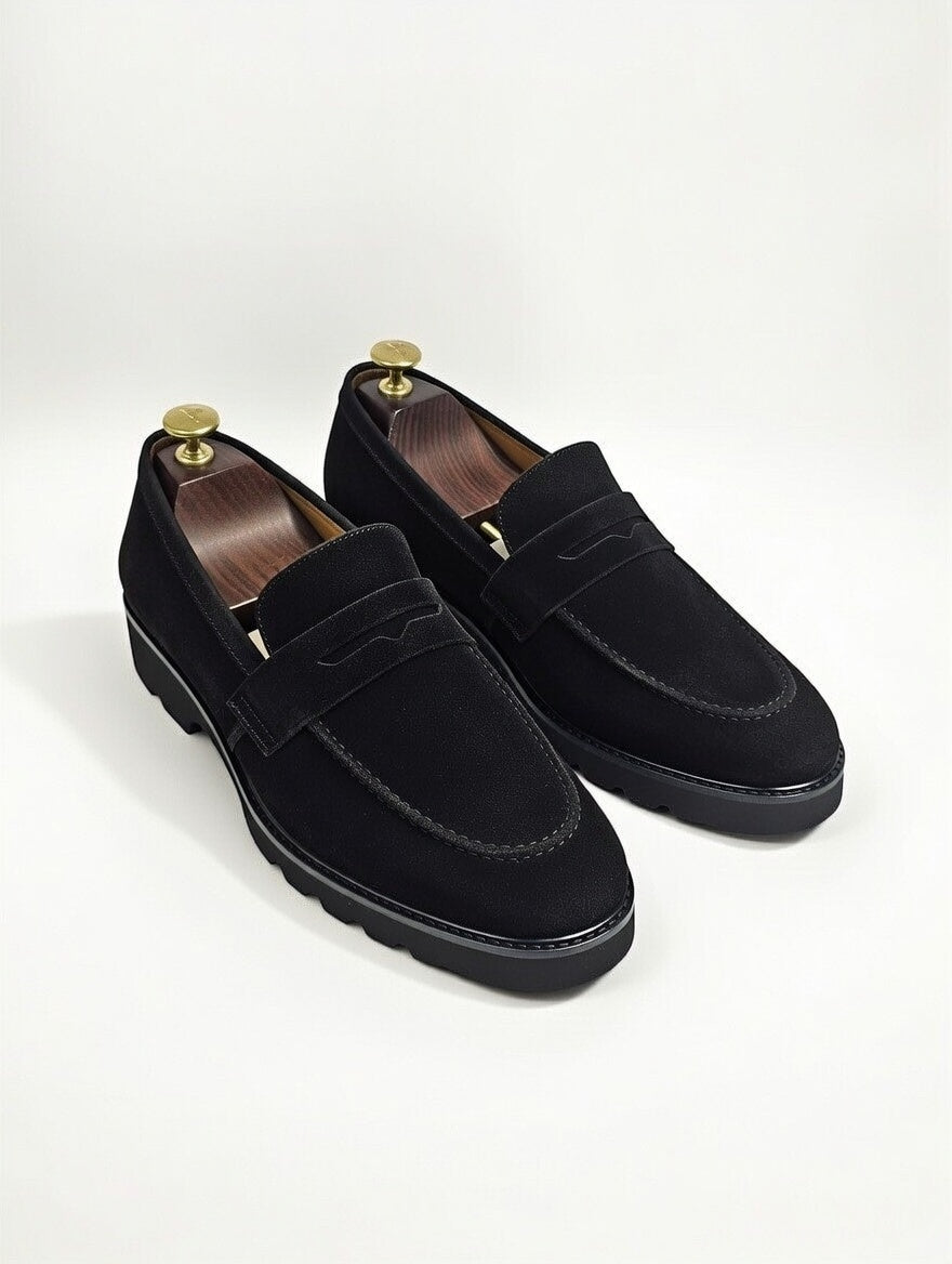 Pair of black loafers on a white background