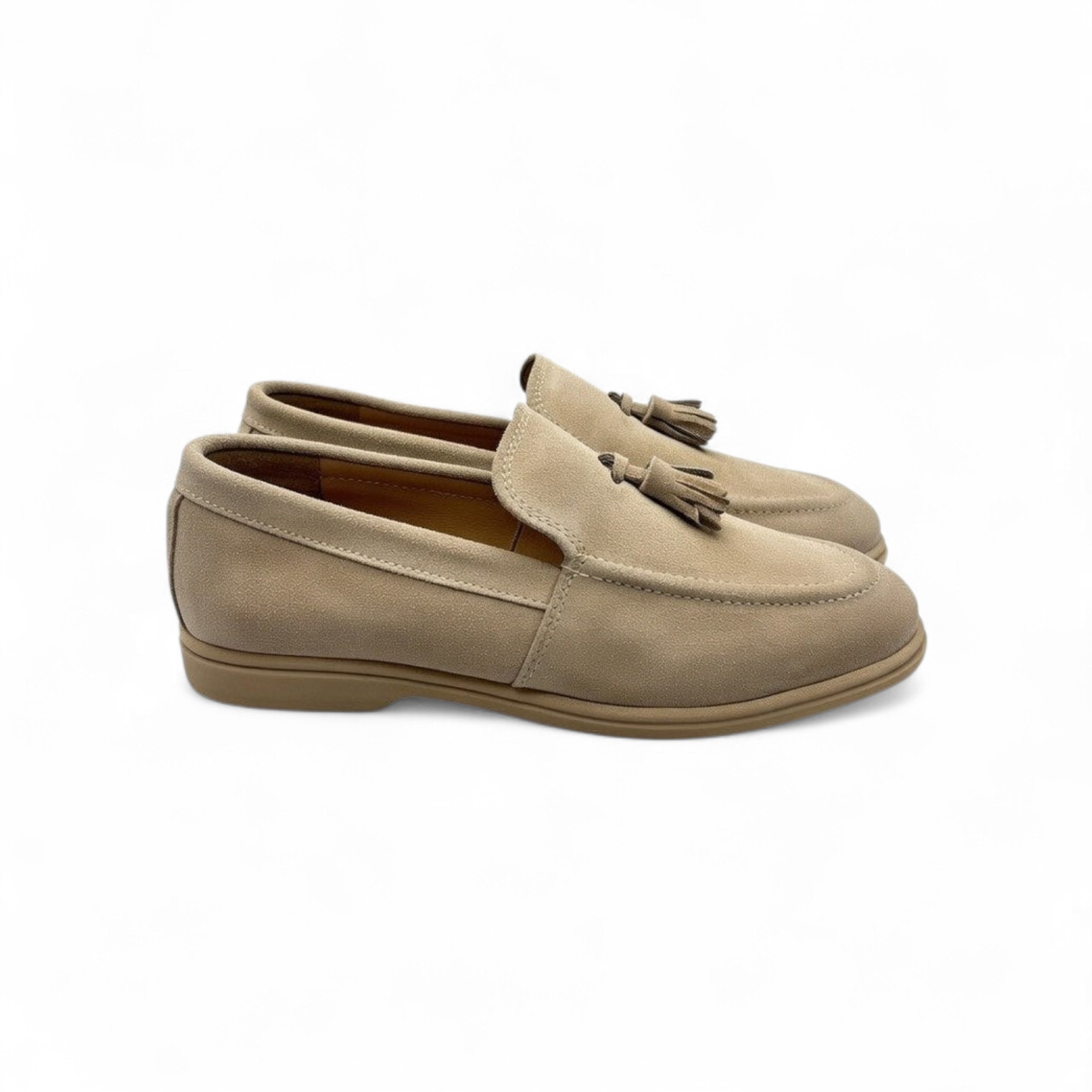 Pair of beige loafers with tassels on a white background