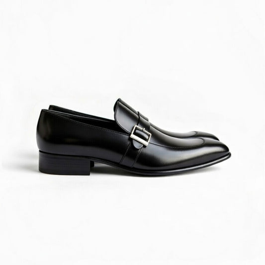 Black glossy loafer with a silver buckle on a white background