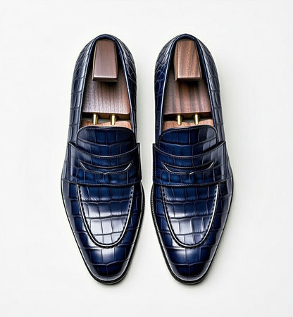 Pair of blue dress shoes with a textured pattern on a white background