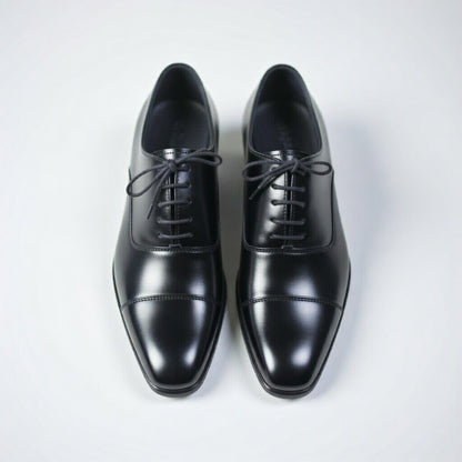 Pair of black dress shoes on a white background