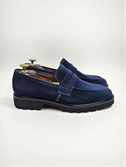 Blue suede loafers on a white background