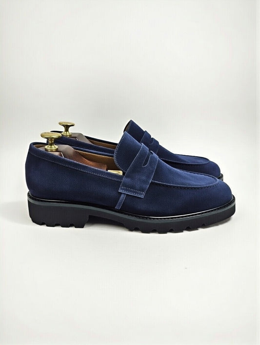 Blue suede loafers on a white background