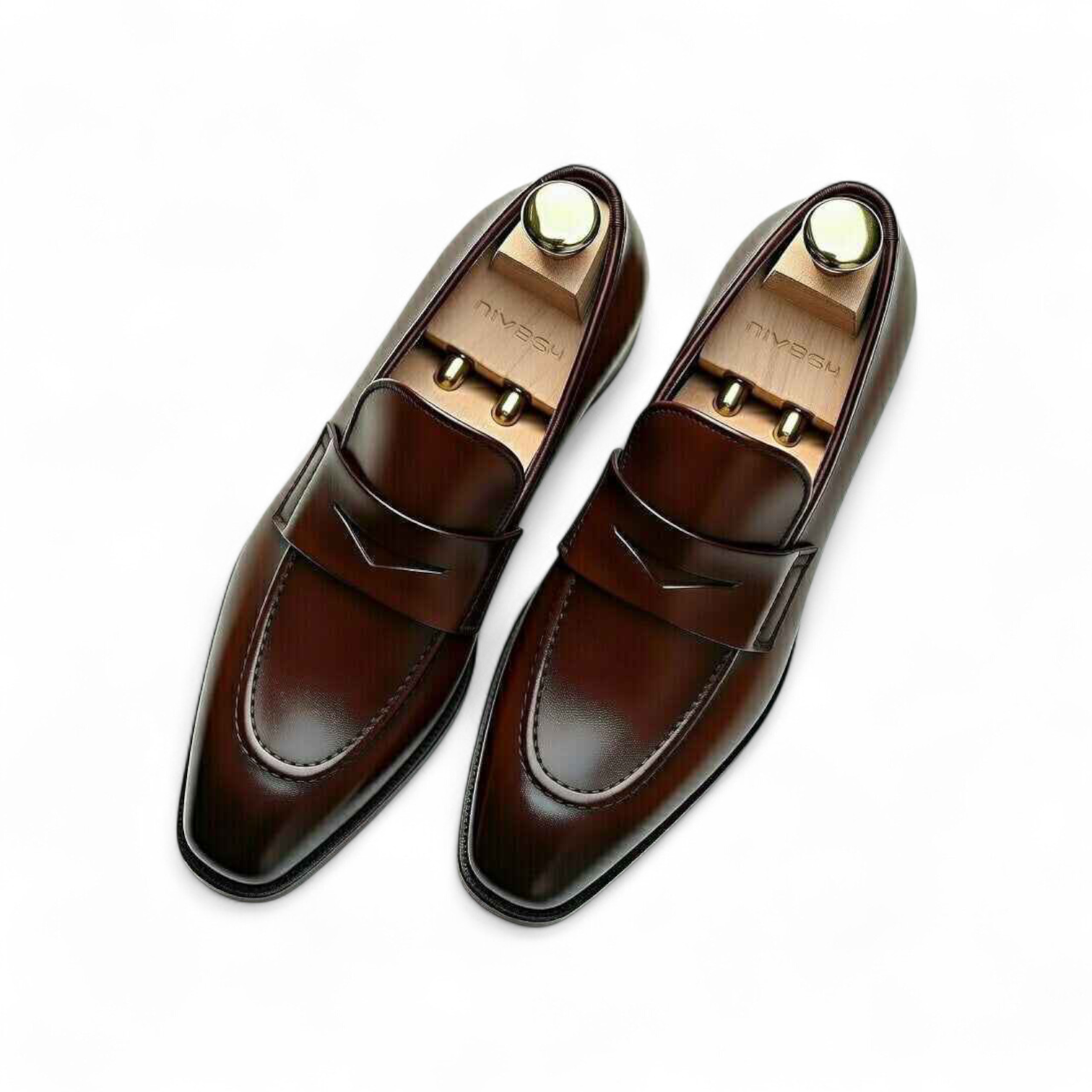 Pair of brown loafers with gold accents on a white background