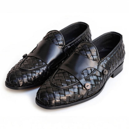 Pair of black leather loafers with woven pattern on a white background