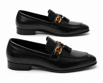 A pair of black leather penny loafers with a green and red web stripe and a gold-tone interlocking G logo on the strap, shown on a white background.