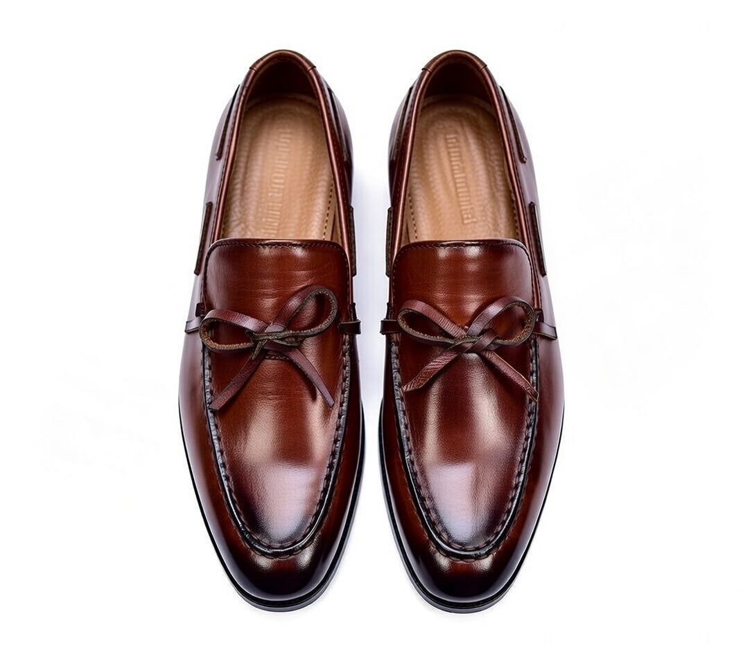 Pair of brown leather loafers on a white background