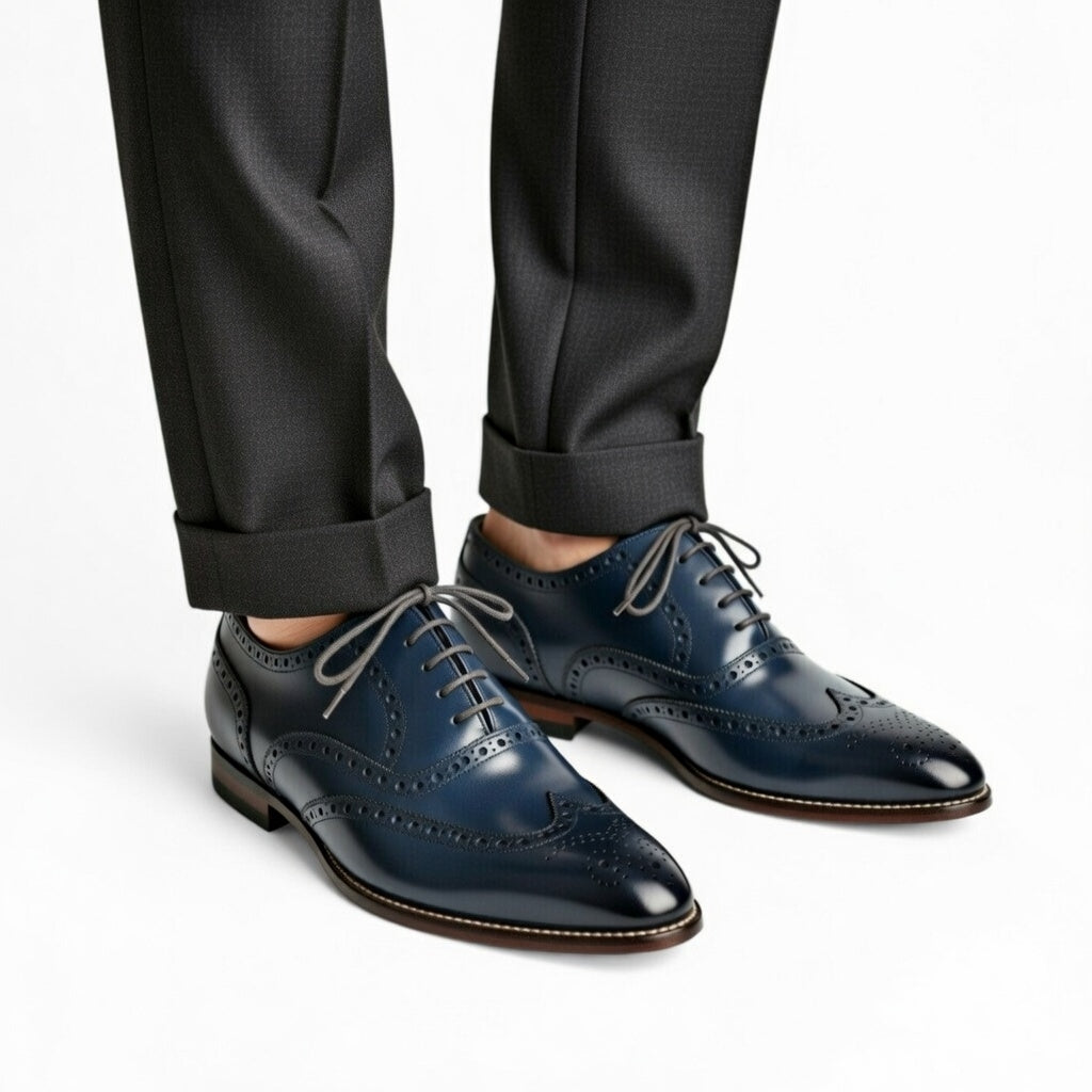 Blue dress shoes worn with black pants on a white background