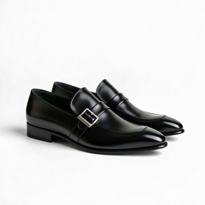 Pair of black dress shoes with a silver buckle on a white background