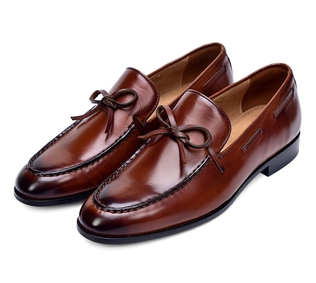 Pair of brown leather loafers on a white background