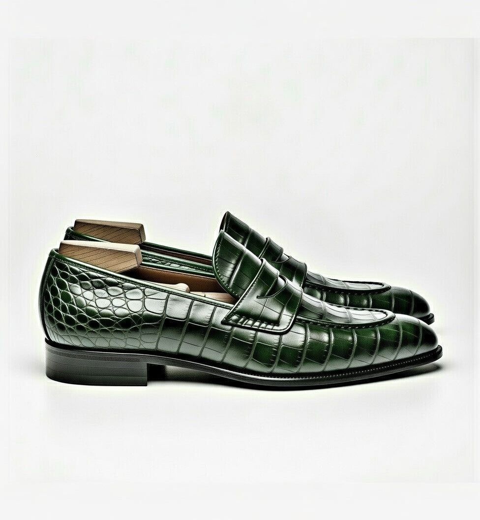 Green crocodile-patterned loafers on a white background