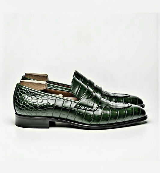 Green crocodile-patterned loafers on a white background