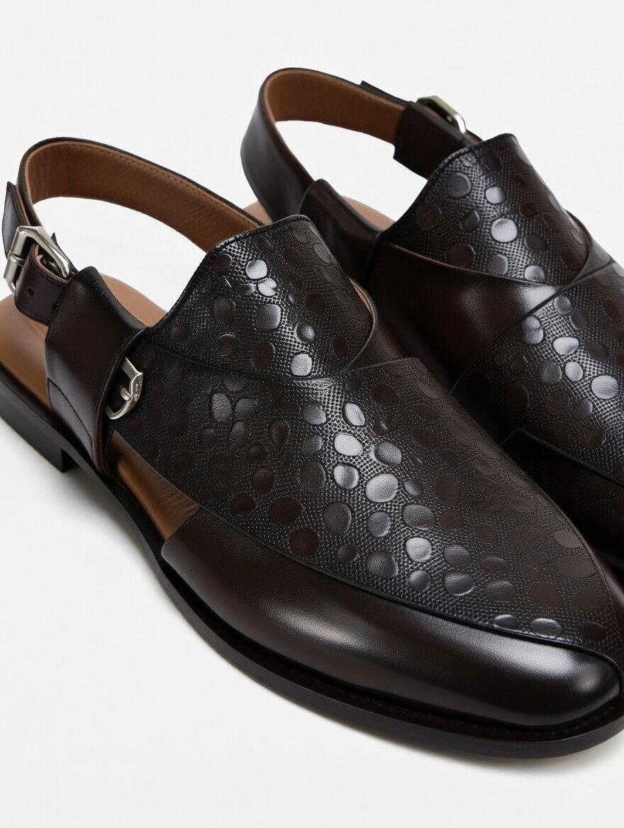 Pair of black leather shoes with cut-out design on a white background