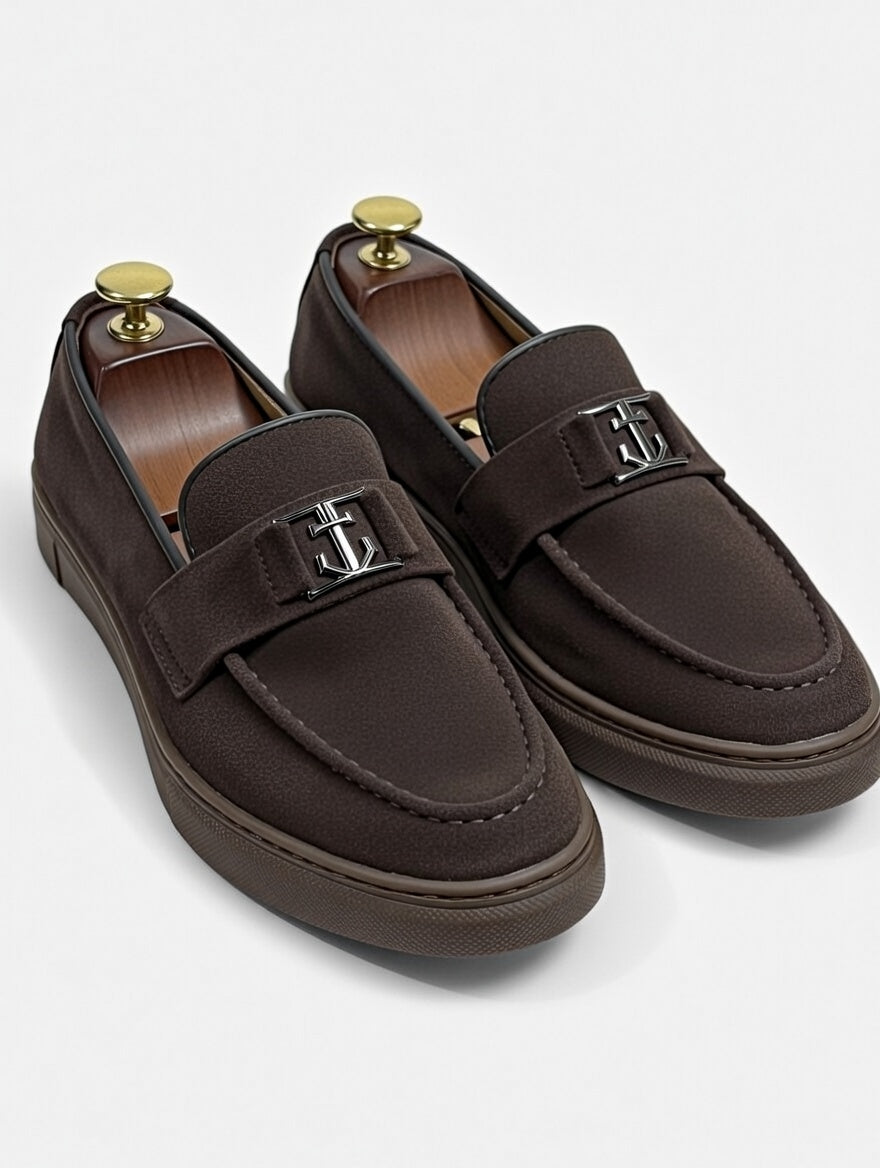 Pair of brown loafers with gold accents on a white background