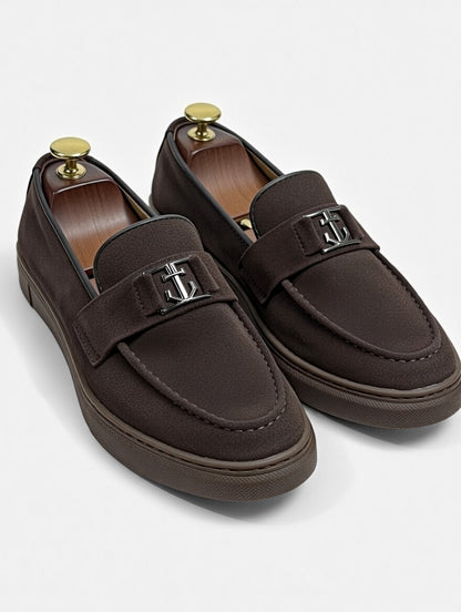 Pair of brown loafers with gold accents on a white background