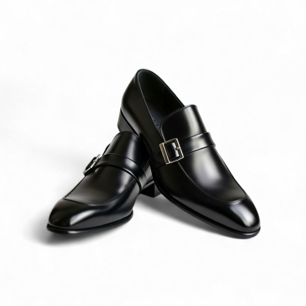 Pair of black dress shoes with buckles on a white background