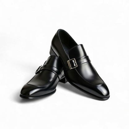 Pair of black dress shoes with buckles on a white background