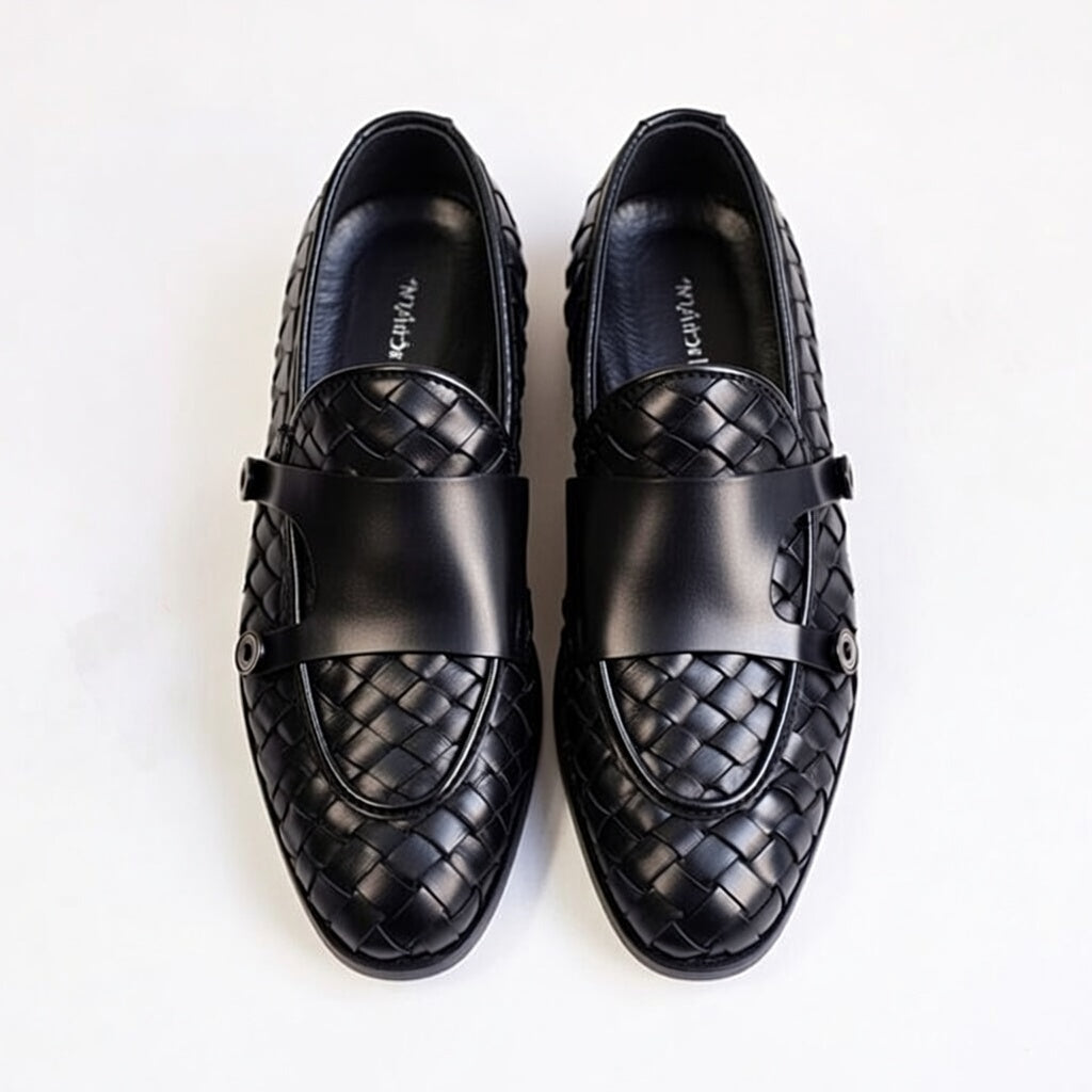 Pair of black leather loafers with woven pattern on a white background