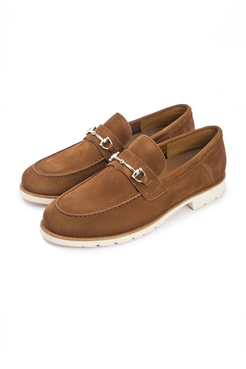 Pair of brown suede loafers with silver buckles on a white background