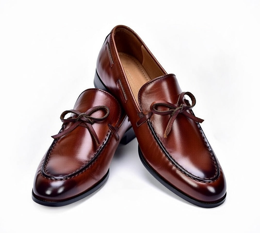 Pair of brown leather loafers on a white background