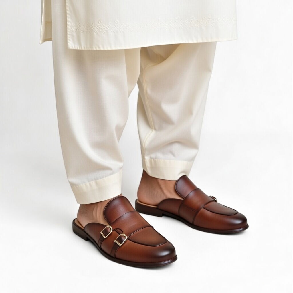 Brown loafers worn with beige pants on a white background