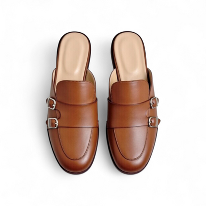 Pair of brown leather mules with buckles on a white background