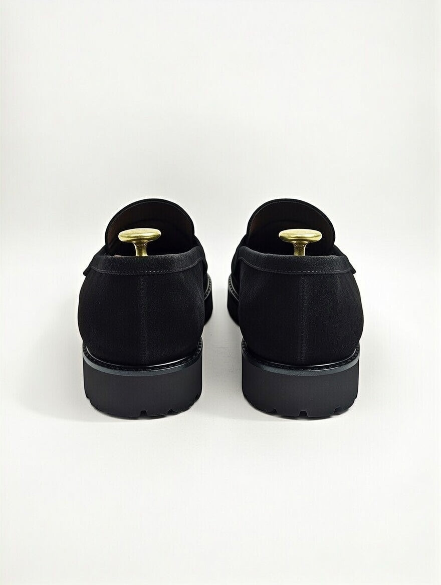 Black shoes with gold accents on a white background